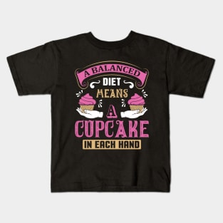 A balanced diet means a cupcake Kids T-Shirt